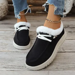 Casual black warm snow boots featuring white faux fur lining and lace-up design on wood