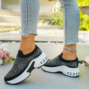 Detailansicht der schwarzen Slip-On-Sneaker mit Strasssteinen und weißer Luftkissen-Keilsohle