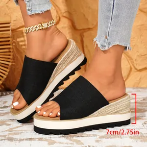 Mules compensées en toile noire avec plateforme de 7 cm et finition corde style espadrille.