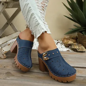 Detailed view of navy blue mule sandals with floral cutouts and chunky platform heels