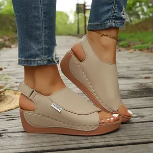 Detail view of stylish beige wedge sandals with thick platform soles for women on feet