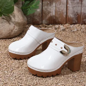 White patent leather platform mules with chunky high heels and metallic rivet details