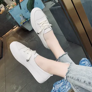 Detailed macro view of women's white casual sneakers worn in a stylish street setting