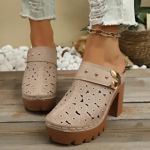 Detailed view of women's beige chunky heel clogs with floral hollow-out pattern.