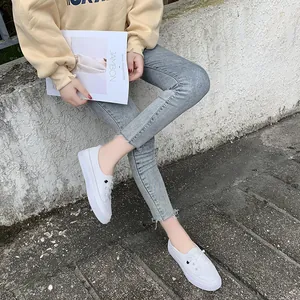Stylish white women's casual board shoes worn with jeans for a modern street look