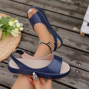 Close-up van donkerblauwe platte sandalen met open neus en een elastische hielband voor dames