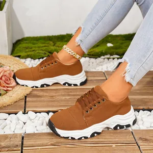 Stylish casual women's chunky brown sneakers featuring thick white soles on a wooden deck