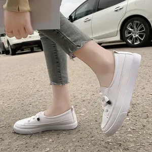 Side view of minimalist white casual sneakers worn outdoors for daily travel