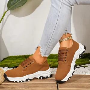 Detailed view of women's brown thick-soled sports sneakers with a lace-up design