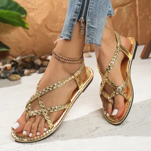 Detailed view of golden braided thong flat sandals with elastic back strap.
