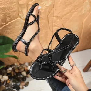Close-up of black braided strappy flat thong sandals for women with elastic back strap