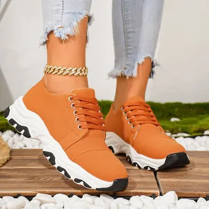 Side view of vibrant orange women's platform sneakers with white chunky sole