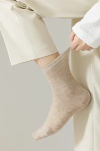 Détail en gros plan d'une chaussette en coton kaki montrant l'élasticité et la maille.