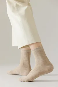 Gros plan sur chaussettes en coton chiné beige pour hommes, style vintage élégant et décontracté.