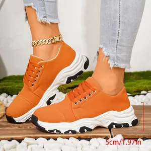 Detailed view of orange platform sneaker with a 5cm thick sole height measurement.