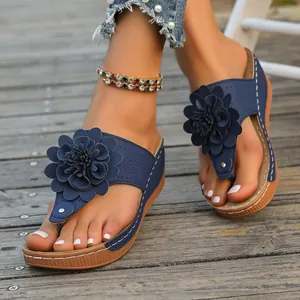 Close-up of blue floral thong wedge sandals with elegant 3D flower decoration.