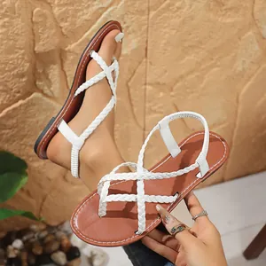 Detailed view of white braided strap thong sandals with comfortable brown flat sole