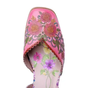 Detalle de sandalias de cuero rosa hechas a mano con bordado floral y bordes festoneados.