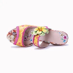 Detailansicht einer handbemalten Ledersandale mit 3D-Blume und gewelltem Rand im Vintage-Stil.