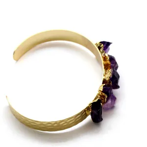 Gold cuff bracelet featuring irregular raw amethyst crystals with hammered texture design