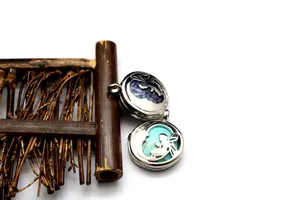 Detailweergave van holle feeënmedaillons met inlays van turkoois en steen.