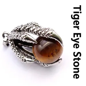 Detailed view of a vintage dragon claw pendant holding a natural tiger eye stone bead.