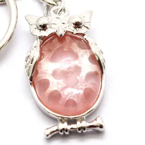Uilvormige sleutelhanger met een roze doorschijnende steen en zilverkleurige ring