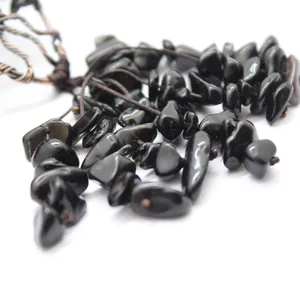 Detalle macro de piedras de obsidiana negra pulida y detalles en hilo de cobre