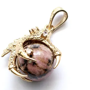 Golden dragon claw pendant holding a round pink rhodonite stone bead on white background