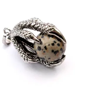 Close-up detail of a medieval dragon claw pendant holding a Dalmatian Jasper bead