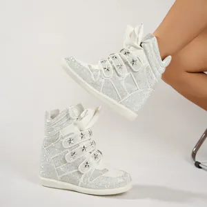 Detail view of white rhinestone high-top wedge sneakers with star-studded Velcro straps