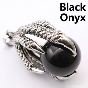 Macro detail of a vintage silver dragon claw pendant holding a polished black onyx sphere.