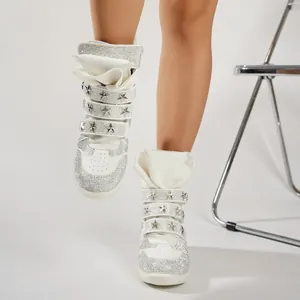 Detailed view of white punk style high-top sneakers with rhinestones and star studs.