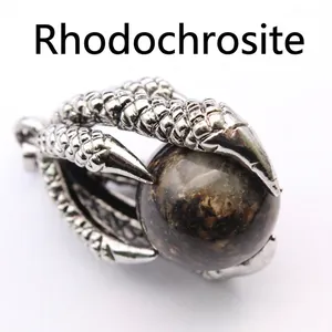Close-up of vintage medieval dragon claw pendant holding a round red vein stone ball