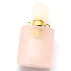 Collana con ciondolo a boccetta di profumo in quarzo rosa e oro su sfondo bianco puro
