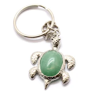 Portachiavi a forma di tartaruga d'argento con guscio in pietra verde su sfondo bianco