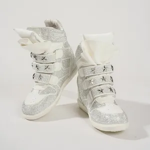 Detailed view of white rhinestone high-top sneakers with star rivets and hidden wedge heel.