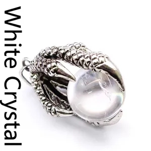 Detailed macro shot of vintage silver dragon claw pendant holding a clear crystal ball