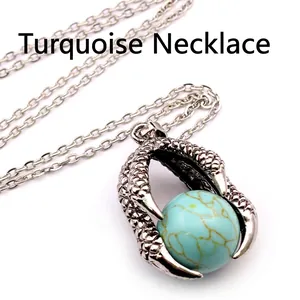 Close-up of retro dragon claw pendant with turquoise bead on a silver chain