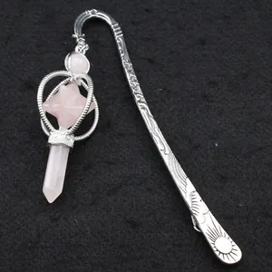 Detalle de marcapáginas de plata grabada con colgante de cristal merkaba de cuarzo rosa