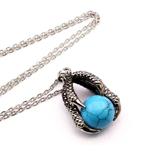 Macro view of retro medieval dragon claw pendant necklace with blue turquoise bead