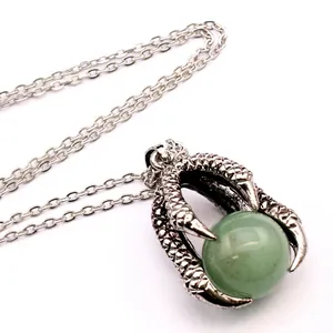 Detail view of a vintage silver dragon claw pendant holding a green aventurine gemstone bead.