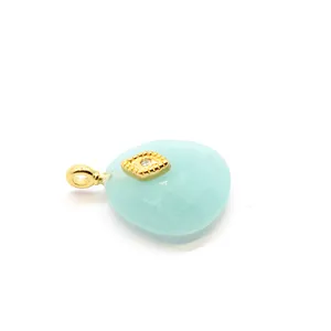 Detailed macro view of a teardrop Amazonite crystal pendant with golden evil eye charm.