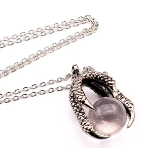 Macro view of vintage silver dragon claw pendant holding a clear crystal ball