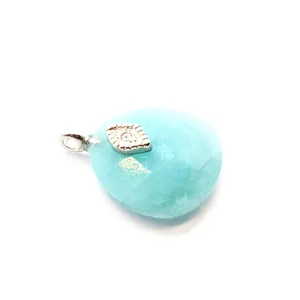 Macro detail of a faceted light blue Amazonite crystal pendant with silver evil eye charm.