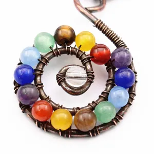 Primer plano de marcapáginas de cobre en espiral con cuentas de cristal chakra