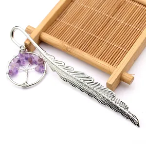Detalle de un marcador de libros de pluma plateada con colgante de árbol de la vida amatista