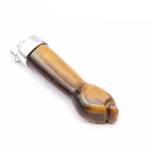 Gedetailleerde macro-opname van een tijgeroog hanger gesneden in een hand.