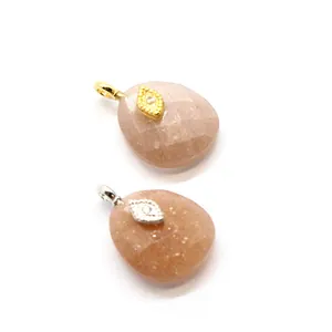 Close-up of peach crystal pendants with gold and silver evil eye accents