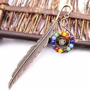 Primer plano de marcador de plumas de bronce con cuentas de cristal en espiral